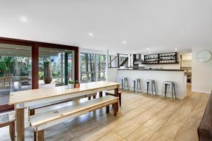 a kitchen and dining room with a table and stools at A Perfect Stay - Jimmys Beach House in Byron Bay