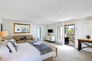 a bedroom with a large bed and a couch at A Perfect Stay - Jimmys Beach House in Byron Bay