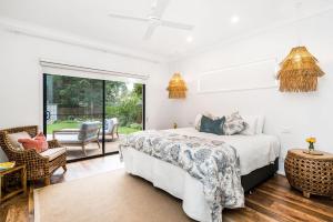 A Perfect Stay - Julian Rocks House في خليج بايرون: غرفة نوم بسرير وفناء
