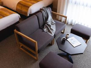 une chambre avec une chaise et une table dans l'établissement Mitsui Garden Hotel Kyoto Sanjo, à Kyoto