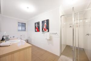 a white bathroom with a shower and a sink at Jordan Springs classic sweet 3Br home WiFi&Parking in Kingswood +21 photos