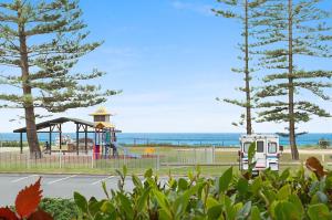a park with a playground next to the ocean at 2 Camden House in Gold Coast