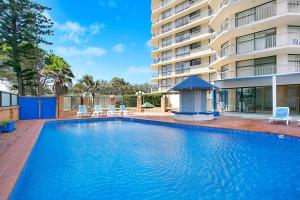 a swimming pool in front of a building at A Perfect Stay - 23C Imperial Surf in Gold Coast