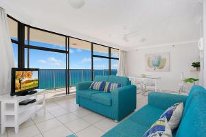 un soggiorno con divano blu e TV di A Perfect Stay - 23C Imperial Surf a Gold Coast