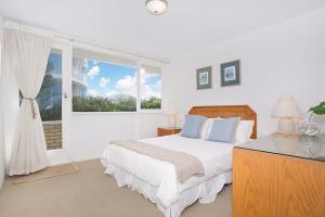 ein weißes Schlafzimmer mit einem Bett und einem Fenster in der Unterkunft A Perfect Stay - King Tide in Gold Coast
