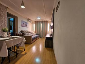 un soggiorno con tavolo e divano di Conforto Urbano, Apartamento Acolhedor a Maringá