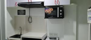 a kitchen with a stove top oven and a microwave at KS RESIDENCES in Manila