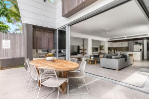 ein Esszimmer und ein Wohnzimmer mit einem Tisch und Stühlen in der Unterkunft A Perfect Stay - KoKos Beach House 2 in Byron Bay