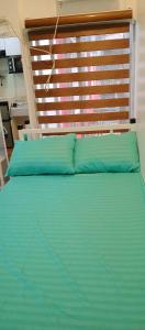 ein Bett mit zwei blauen Kissen in einem Zimmer in der Unterkunft KS RESIDENCES in Manila