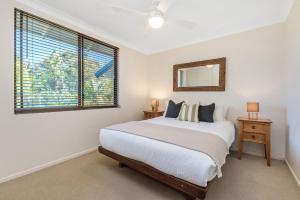 a bedroom with a bed and a window and a mirror at A Perfect Stay - Lisas on Lawson in Byron Bay