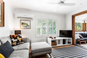 uma sala de estar com um sofá e uma televisão em A Perfect Stay - Little Geckos em Byron Bay