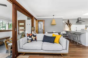 sala de estar con sofá y cocina en A Perfect Stay - Little Geckos, en Byron Bay