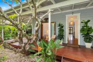 un porche de una casa con un árbol en A Perfect Stay - Margaret, en Byron Bay