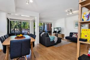 uma sala de jantar e sala de estar com mesa e cadeiras em A Perfect Stay - Mahogany Lodge em Byron Bay