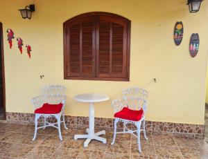 阿拉魯阿馬的住宿－Casa em Condomínio com Piscina Privativa，墙上的房间里摆放着两把椅子和一张桌子