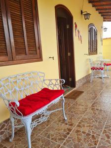 Casa em Condomínio com Piscina Privativa في أرارواما: مقعد أبيض عليه بطانية حمراء