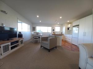 a living room with a kitchen and a dining room at Anchor watch in Whangamata