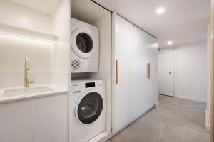 a white laundry room with a washer and dryer at A Perfect Stay - Pacific Blue in Byron Bay