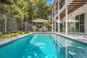 a swimming pool in front of a house at A Perfect Stay - Pompano House Byron Bay in Suffolk Park