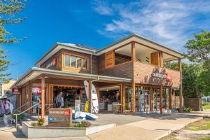 a store front with a wooden house at A Perfect Stay - Quiksilver Apartments The Pass in Byron Bay