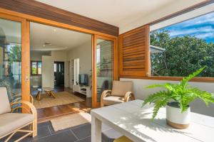 a living room with a table and chairs and a large window at A Perfect Stay - Quiksilver Apartments The Wreck in Byron Bay