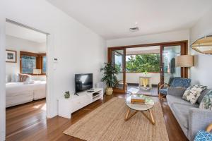 a living room with a couch and a tv at A Perfect Stay - Quiksilver Apartments The Wreck in Byron Bay