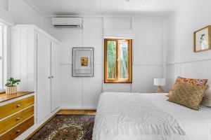 ein weißes Schlafzimmer mit einem Bett und einem Fenster in der Unterkunft A Perfect Stay - San Juan Surfers Cottage in Byron Bay
