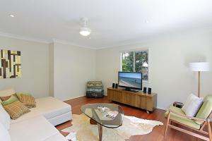 a living room with a couch and a tv at A Perfect Stay - Su Casa in Byron Bay