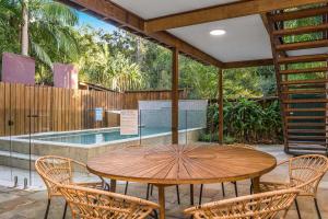 a patio with a table and chairs and a swimming pool at A Perfect Stay - Skye Lodge in Byron Bay