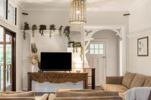 a living room with a tv on a table at Skye Lodge - 7 Bedroom charming Balinese retreat with designer pool in Byron Bay