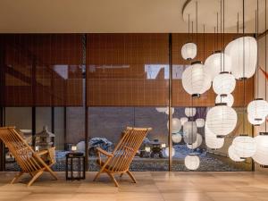 a room with two chairs and chandeliers at Mitsui Garden Hotel Kyoto Shijo in Kyoto