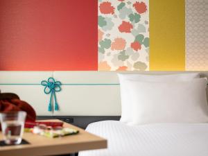 a hotel room with a bed and a table with a table at Mitsui Garden Hotel Kyoto Shijo in Kyoto