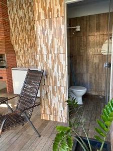 a bathroom with a toilet and a chair on a patio at Pousada Luciana Dias in Palmas