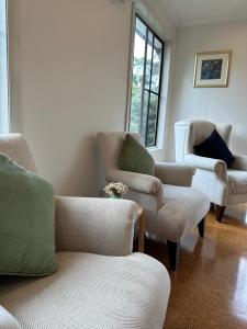 ein Wohnzimmer mit Sofas, Stühlen und Fenstern in der Unterkunft Two Twenty Two Farm Stay in Grassy