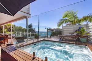 a house with a swimming pool and a deck with a bench at A Perfect Stay - The Palms at Byron in Byron Bay