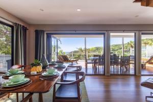 a dining room with a table and chairs and a balcony at A Perfect Stay - The Palms at Byron in Byron Bay