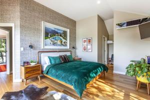 a bedroom with a bed with a green bedspread at A Perfect Stay - The Palms at Byron in Byron Bay