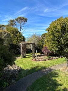 a garden with a stone arch in the grass at Two Twenty Two Farm Stay in Grassy