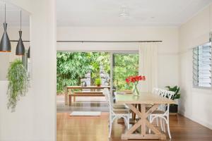 a dining room with a wooden table and chairs at A Perfect Stay - The White Rabbit in Byron Bay