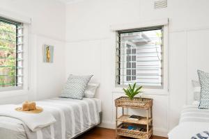 Habitación blanca con cama y ventana en A Perfect Stay - The White Rabbit, en Byron Bay