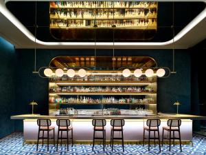 a bar with stools and a shelf of liquor bottles at Parnas Hotel Jeju in Seogwipo