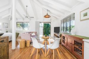uma sala de estar com uma mesa e duas cadeiras brancas em A Perfect Stay - Twin Tallows em Bangalow