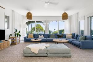 a living room with a blue couch and a tv at A Perfect Stay - Villa St Helena in Byron Bay