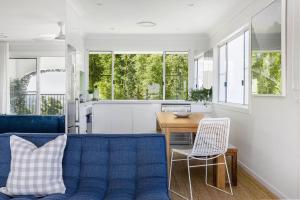 a living room with a blue couch and a kitchen at A Perfect Stay - Villa St Helena in Byron Bay
