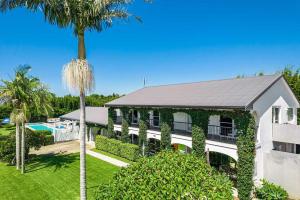 an exterior view of a building with a palm tree at A Perfect Stay - Villa St Helena in Byron Bay