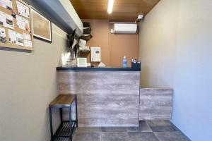 a bar in a restaurant with a counter and benches at HOTEL R9 The Yard Kikuchikyokushiisaka in Sugimizu