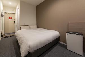 um quarto com uma grande cama branca num quarto em HOTEL R9 The Yard Kikuchikyokushiisaka em Sugimizu