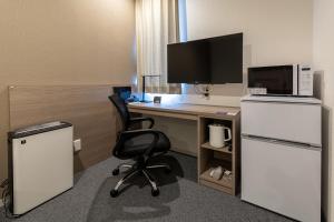 an office with a desk with a microwave and a chair at HOTEL R9 The Yard Kikuchikyokushiisaka in Sugimizu