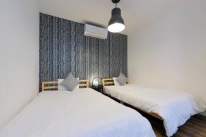 2 Betten nebeneinander in einem Zimmer in der Unterkunft HOTALU Universal Vacation - Kan in Osaka