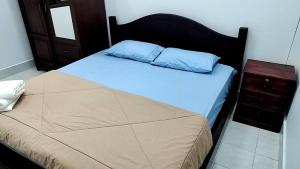 a bedroom with a bed with a blue pillow and a night stand at CS Apartment in Vientiane